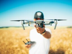 Beginner drone pilot holding a camera drone outdoors while learning safe drone flying and basic piloting techniques.
